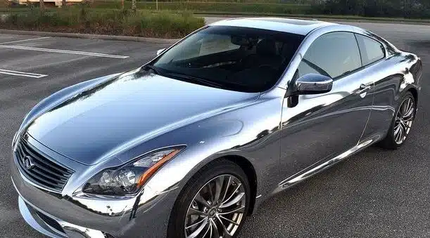 Close-up photo illustrating edge wear on a chrome car wrap after extended exposure, contrasted with gloss and matte panels.